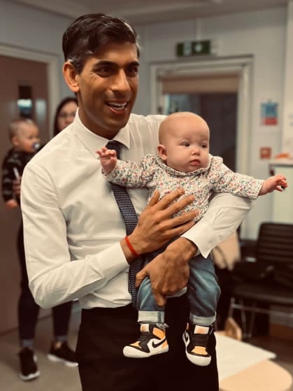 British Prime Minister, Rishi Sunak, holds a baby from a family supported by Home-Start Kernow