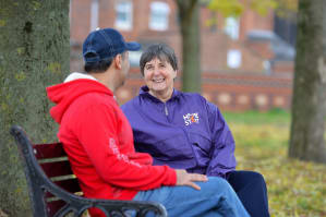 Home-Start volunteer and dad sitting on park bench talking